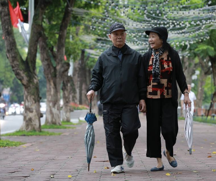 Đôi bạn già thong thả nắm tay nhau dạo bước ngày gió mùa chợt thổi mạnh hơn. Ảnh Trí Thức Trẻ