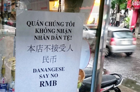Nhạc sĩ Nguyễn Duy Khoái treo bảng thông báo không nhận Nhân dân tệ ngay trước quán nước của mình. Ảnh: Zing.vn