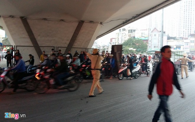 Cảnh sát giao thông điều tiết phương tiện khi nhiều người hiếu kỳ dừng lại xem