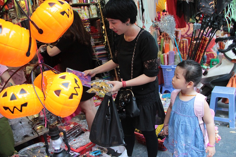 Một bậc phụ huynh đang chọn mua con vật trang tr&iacute; phổ biến trong Halloween l&agrave; nhện. Gi&aacute; một vỉ nhận 3 con lớn l&agrave; 50.000 đồng