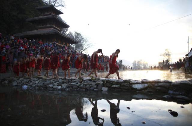 Tín đồ qua sông Triveni sau khi tắm dòng nước thánh trong lễ hội Bratakatha Swasthani ở  Panauti gần Kathmandu.
