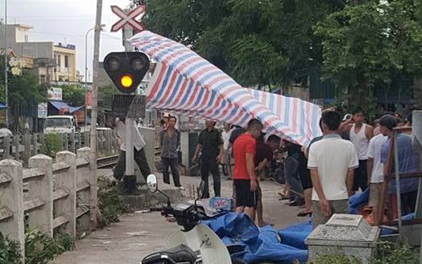 Thi thể nam sinh tử vong v&igrave; tai nạn giao th&ocirc;ng được mọi người đưa v&agrave;o lề đường sắt