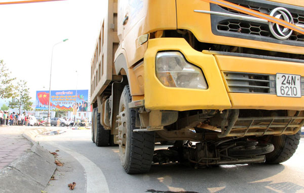 Chiếc xe m&aacute;y nằm gọn trong gầm xe tải tại hiện trường vụ tai nạn giao th&ocirc;ng