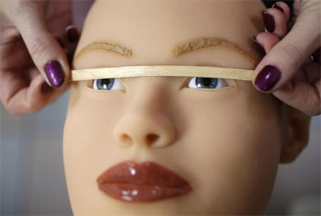 Nhân viên của Dreamdoll kiểm tra xem mắt của một búp bê tình dục này đã cân đối hay chưa.