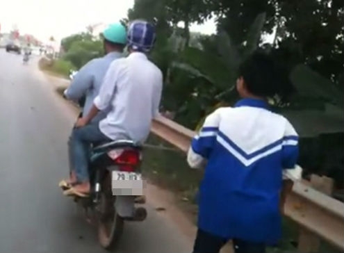 Bố x&iacute;ch con v&agrave;o sau xe m&aacute;y v&igrave; bỏ nh&agrave; đi chơi game