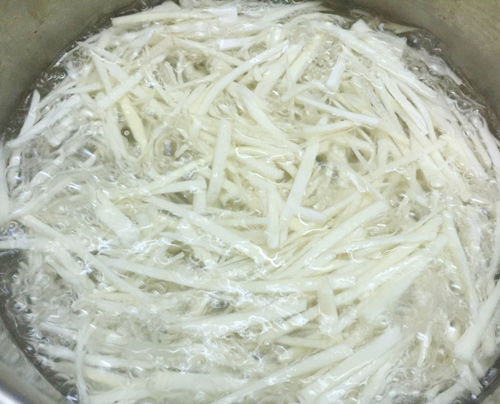 Măng lột vỏ, rửa sạch, th&aacute;i sợi rồi ng&acirc;m trong nước khoảng 60 ph&uacute;t trước khi luộc 