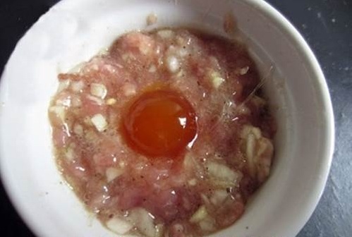 Trộn đều thịt băm với h&agrave;nh băm nhỏ, b&uacute;n t&agrave;u v&agrave; c&aacute;c gia vị rồi đặt quả trứng muối l&ecirc;n tr&ecirc;n