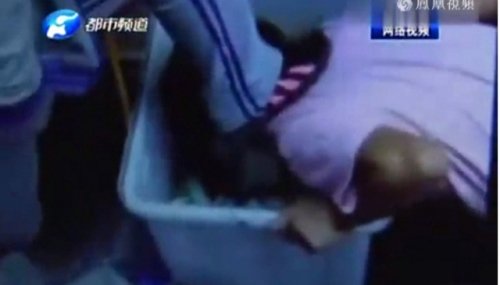 Trong đoạn clip nữ sinh Trung Quốc đang g&acirc;y x&ocirc;n xao, kẻ bắt nạt &eacute;p nạn nh&acirc;n quỳ gối bới r&aacute;c bằng miệng