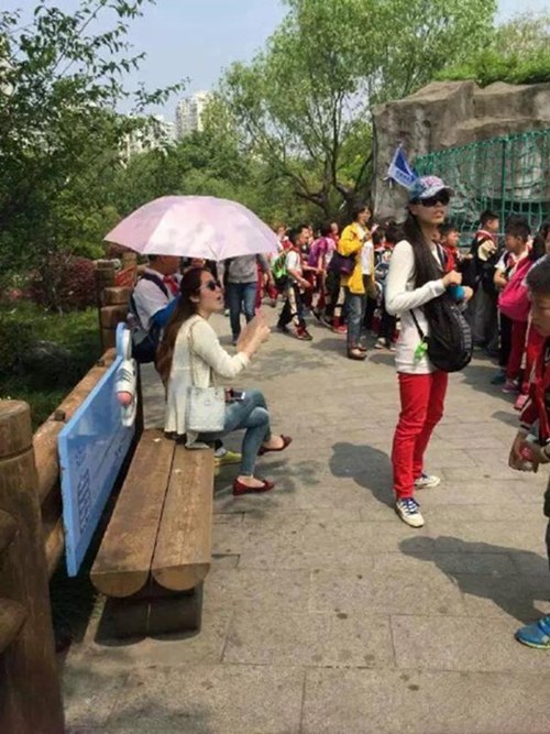 Ngay cả khi ngồi nghỉ, bên cạnh cô giáo người Trung Quốc này vẫn luôn có cậu học trò nhỏ cầm ô che nắng Ngay cả khi ngồi nghỉ, bên cạnh cô giáo người Trung Quốc này vẫn luôn có cậu học trò nhỏ cầm ô che nắng
