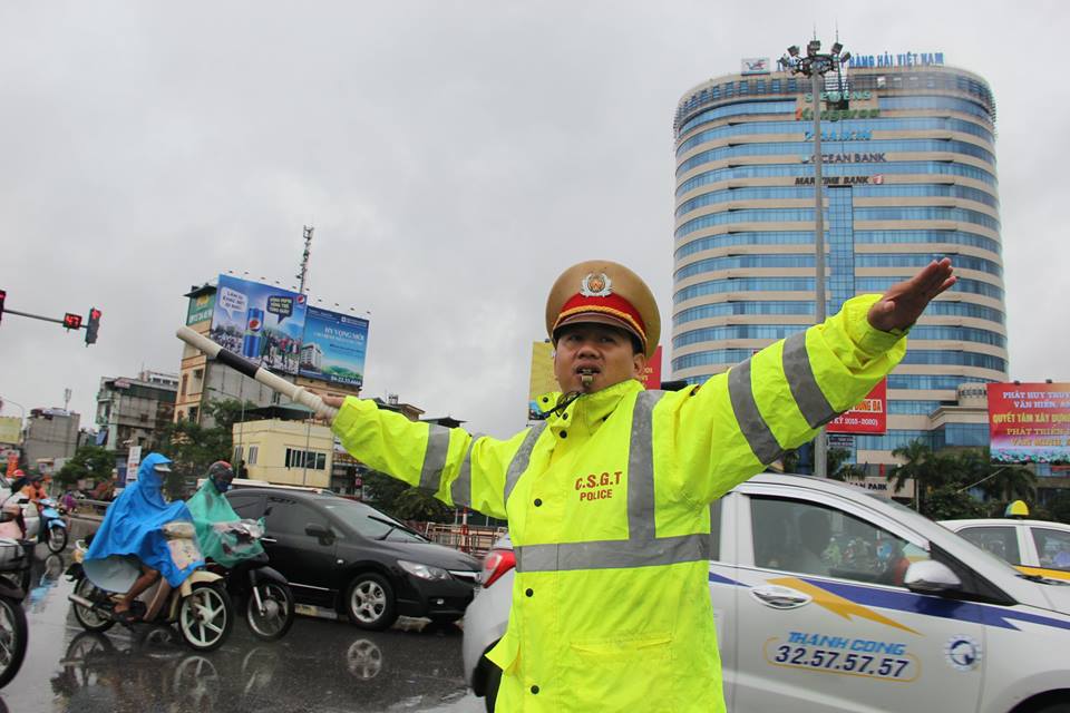 Một c&aacute;n bộ CSGT H&agrave; Nội đang ph&acirc;n l&agrave;n giao th&ocirc;ng trong mưa b&atilde;o
