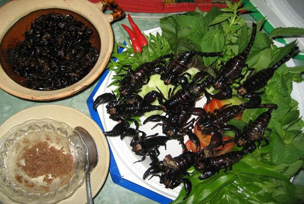 Bò cạp: Đến hai huyện miền núi Tịnh Biên và Tri Tôn, An Giang bạn không thể bỏ qua món đặc sản bò cạp chiên giòn. Bò cạp là loại côn trùng có hình dáng kỳ dị, to bằng con dế cơm, đuôi nhọn hoắt và hai càng to tướng, đuôi dài, đen nhánh đáng sợ. Loại này thường ẩn náu ở những hốc cây mục, kẽ đá, nơi có nhiều bụi rậm và cao ráo. Bò cạp bắt về cho vào thau vài ngày cho sạch bụng, để nguyên con rửa sạch, cho vào chảo mỡ hoặc dầu đang sôi. Trong chốc lát, bò cạp chín, bốc mùi thơm phức .