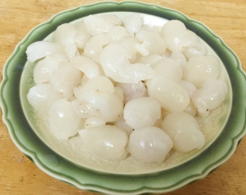 Vải thiều b&oacute;c vỏ, bỏ hạt rồi cho v&agrave;o m&aacute;y &eacute;p