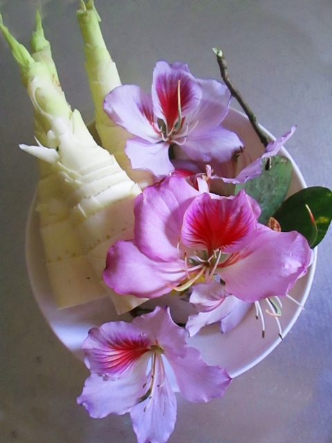 Hoa ban đẹp, không chỉ để ngắm, đó còn là nguyên liệu để làm món ăn cực “đã”: nộm măng đắng hoa ban. Măng đắng sắt nhỏ, ngâm muối, ngâm nước rồi luộc 2 lần rồi vớt ra để ráo. Cá suối tươi đem nướng gỡ lấy thịt. Sau đó, pha hỗn hợp nước, chanh, tỏi, ớt, rau húng và rau mùi thái nhỏ. Cho tất cả các thành phần là hoa ban, cá, măng vào trộn cùng hỗn hợp vừa pha. Vừa đảo, vừa nghe mùi cuốn hút rớt nước miếng. Tất cả hoà quyện tạo nên một hương vị đặc trưng của núi rừng, gắp từng miếng nộm du khách cảm nhận được vị đậm đà, thơm nồng của cá nướng, vị bùi bùi, ngầy ngậy của hoa ban, và  vị đăng đắng của măng tươi  Giữa xứ này gắp từng miếng nộm măng hoa ban cho nhau thì quả là kỉ niệm không thể quên.Đến khi về xuôi rồi cũng còn nhớ mãi cái chua chua, ngọt ngọt, thơm thơm đủ vị của núi rừng trong món ăn dễ chiều lòng khách này.