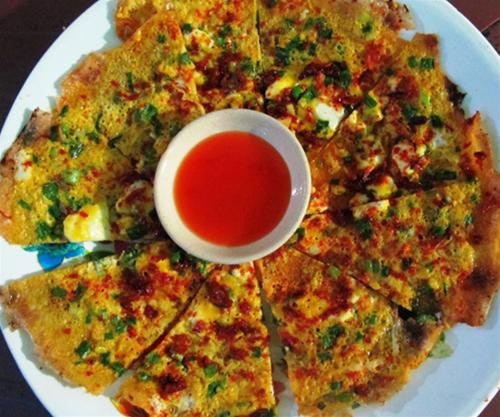 Dù ngày nay, món “Pizza Việt Nam” này đã trở nên rất nổi tiếng nhưng đến Đà Lạt, không phải ai cũng có cơ hội khám phá món ăn độc đáo của phố núi này. Gọi bánh tráng nướng là pizza Việt Nam hay pizza phố núi cũng không quá lời bởi từ hình thức cũng nhưng các nguyên liệu bánh tráng nướng đều có vẻ giống món pizza bạn đã từng biết.  Sự khác biệt độc đáo nằm ở phần đế bánh, chiếc pizza Việt Nam có đế bánh làm từ nguyên liệu rất Việt ấy là chiếc bánh tráng. Những chiếc bánh tráng Đà Lạt chính hiệu mỏng tang, đặt trên vỉ than nướng giòn, thêm chút hành lá xào nhuyễn, mỡ hành thơm nức, ruốc thịt đậm đà. Kế đến là lớp trứng gà tráng mỏng vàng ươm cùng các phụ liệu độc đáo khác.  Có rất nhiều thứ có thể cho vào bánh tráng nướng, tùy theo sở thích mà có thể chọn bánh tráng nướng bò khô, hay pa tê, phô mai, thịt gà, xúc xích, sốt maiyonaise…