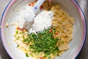 Cho th&ecirc;m v&agrave;o khoai m&igrave; bột c&agrave; ri, bột năng, bột m&igrave;, tỏi băm nhuyễn, ớt bỏ hột cắt kh&uacute;c, 1 muỗng muối, 1 muỗng hạt n&ecirc;m v&agrave; 1 muỗng đường.