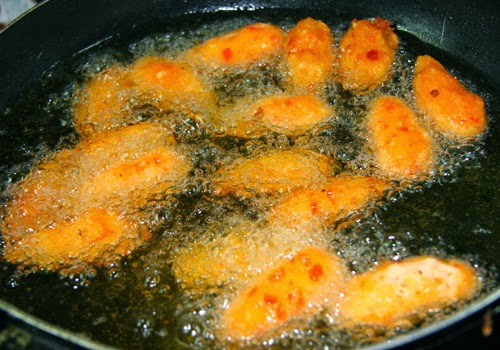Hạ xuống lửa vừa, thả từng c&aacute;i b&aacute;nh v&agrave;o chi&ecirc;n đến khi v&agrave;ng gi&ograve;n.