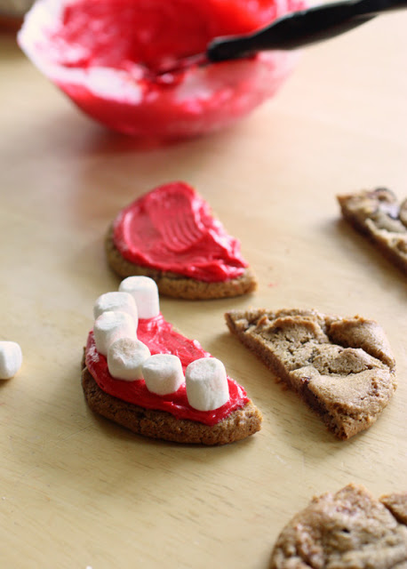 Bước 3: Sau đ&oacute;, đặt v&agrave;o m&eacute;p b&aacute;nh 6 chiếc kẹo dẻo marshmallows tạo th&agrave;nh h&igrave;nh h&agrave;m răng.