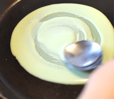 L&agrave;m vỏ b&aacute;nh: Đặt chảo (chảo lớn hoặc chảo l&agrave;m b&aacute;nh crepe) l&ecirc;n bếp, vặn lửa nhỏ rồi tr&aacute;ng qua 1 lớp mỏng dầu ăn. Sau d&oacute;, cho 2 th&igrave;a canh bột b&aacute;nh đ&atilde; chuẩn bị ở tr&ecirc;n v&agrave;o ch&iacute;nh giữa chảo rồi trải đều ra để th&agrave;nh vỏ b&aacute;nh tr&ograve;n.