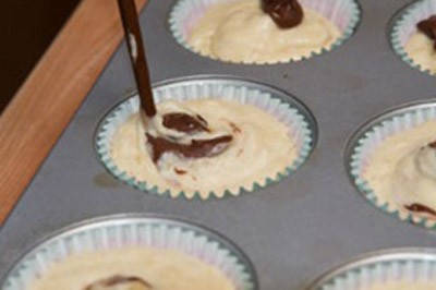 Chia bột ra từng khu&ocirc;n giấy khoảng chừng &frac34; khu&ocirc;n. Nếu th&iacute;ch th&ecirc;m chocolate, mỗi chiếc b&aacute;nh th&ecirc;m 1 th&igrave;a c&agrave; ph&ecirc; xốt nutella v&agrave;o từng khu&ocirc;n, rồi khuấy nhẹ l&ecirc;n để nutella quyện v&agrave;o với bột b&aacute;nh.