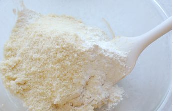 Lấy một b&aacute;t ri&ecirc;ng, đổ hạnh nh&acirc;n, r&acirc;y đường bột v&agrave; cho 1 &iacute;t muối rồi trộn ch&uacute;ng lại với nhau.