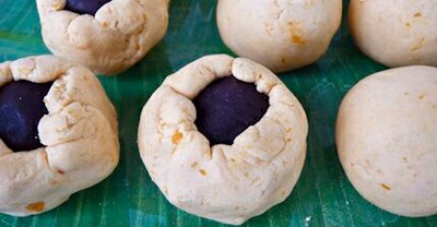 Xoa dầu ăn v&agrave;o tay cho khỏi d&iacute;nh rồi d&ugrave;ng tay ấn dẹt phần vỏ b&aacute;nh, bỏ nh&acirc;n đậu đỏ v&agrave;o ch&iacute;nh giữa sau đ&oacute; vo tr&ograve;n lại.