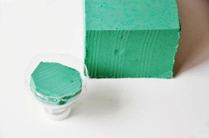 Cắt vỏ chai nhựa l&agrave;m hai phần, mỗi phần sẽ d&ugrave;ng cho một chậu. Cắt xốp vừa với phần vỏ chai v&agrave; đặt v&agrave;o đ&oacute;. Ng&acirc;m xốp trong nước cho ngấm đều. Vỏ chai nhựa sẽ gi&uacute;p cho xốp kh&ocirc;ng l&agrave;m ẩm nước v&agrave; cọ bẩn v&agrave;o th&agrave;nh chậu đất nung.
