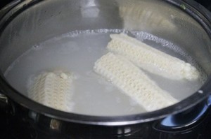 Tiếp theo đổ gạo nếp v&agrave;o nồi, th&ecirc;m khoảng hai b&aacute;t con nước lọc, cho c&ugrave;i bắp v&agrave;o đun c&ugrave;ng đến khi gạo nếp nở, bạn vớt bỏ c&ugrave;i bắp đi.