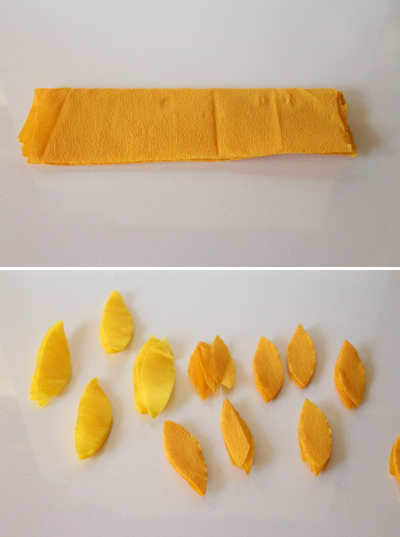 Đầu ti&ecirc;n, h&atilde;y cắt giấy crepe v&agrave;ng th&agrave;nh c&aacute;c tấm h&igrave;nh chữ nhật, gấp đ&ocirc;i lại rồi cắt h&igrave;nh chiếc l&aacute; để l&agrave;m c&aacute;nh hoa. Để cắt nhiều v&agrave; nhanh c&aacute;c c&aacute;nh hoa n&ecirc;n gấp c&aacute;c tấm giấy xếp chồng l&ecirc;n nhau rồi cắt theo 1 mẫu. Cắt giấy m&agrave;u v&agrave;ng l&agrave;m c&aacute;nh hoa lớn, m&agrave;u cam l&agrave;m c&aacute;nh hoa nhỏ hơn. Hoa hướng dương c&oacute; rất nhiều c&aacute;nh, do đ&oacute; n&ecirc;n cắt thật nhiều c&aacute;nh hoa nh&eacute;!
