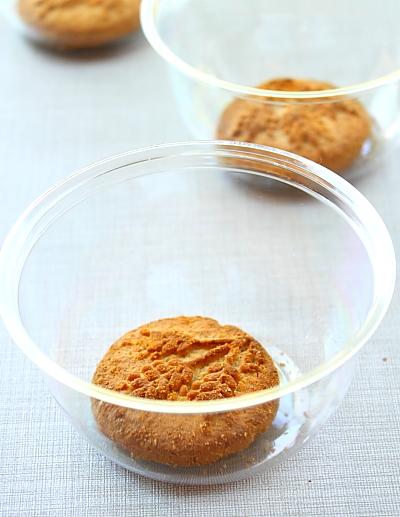 Chuẩn bị c&aacute;c hũ thủy tinh hoặc hũ nhựa sạch đựng kem sữa chua. Cho v&agrave;o mỗi hũ 1 chiếc b&aacute;nh quy gi&ograve;n đặt ph&iacute;a dưới c&aacute;c bạn nh&eacute;!