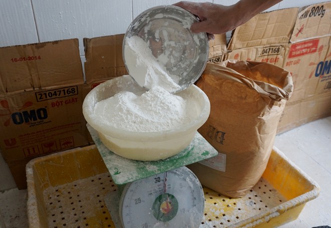 Cân đong, chia bột cho mỗi mẻ bánh ngay gần quầy. Theo chủ xưởng, bột làm bánh là loại bột trắng mịn, được làm từ gạo ngon, thơm và phải là gạo mới để có độ dẻo dai.