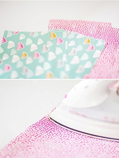 Cắt vải cotton m&agrave;u xanh v&agrave; m&agrave;u hồng th&agrave;nh 2 tấm h&igrave;nh chữ nhật với k&iacute;ch thước 23x15cm. Sau đ&oacute;, d&ugrave;ng b&agrave;n l&agrave; l&agrave; phẳng c&aacute;c tấm vải đ&atilde; cắt.