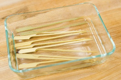Ngâm xiên que trong nước khoảng 30 phút. Việc ngâm xiên que này sẽ giúp que tre không bị cháy khi nướng.