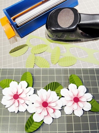 Cắt giấy m&agrave;u xanh th&agrave;nh những h&igrave;nh bầu dục, gấp đ&ocirc;i h&igrave;nh bầu dục đưa qua m&aacute;y &eacute;p zic zac tạo h&igrave;nh g&acirc;n l&aacute;. Kh&ocirc;ng c&oacute; dụng cụ &eacute;p c&oacute; thể d&ugrave;ng đầu b&uacute;t bi hết mực để vẽ đường g&acirc;n l&aacute;. Cần tất cả 6 chiếc l&aacute;, d&aacute;n 2 chiếc l&aacute; v&agrave;o mặt sau của mỗi b&ocirc;ng hoa.