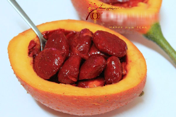 Gấc bổ đôi, móc lấy thịt gấc, trộn vào thịt gấc 1 thìa rượu trắng, để yên qua đêm hay vài giờ đồng hồ.