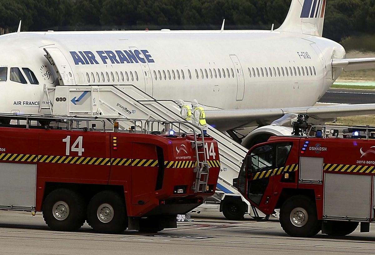 Nh&acirc;n vi&ecirc;n y tế mặc quần &aacute;o bảo hộ đứng b&ecirc;n cạnh m&aacute;y bay A321 của Air France Airbus. Chiếc m&aacute;y bay đ&atilde; hạ c&aacute;nh xuống s&acirc;n bay quốc tế Barajas ở thủ đ&ocirc; Madrid của T&acirc;y Ban Nha v&agrave;o ng&agrave;y 16 Th&aacute;ng Mười năm 2014