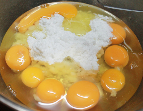 R&acirc;y đều hỗn hợp bột m&igrave;, bột nở, muối nở v&agrave;o trong hỗn hợp trứng