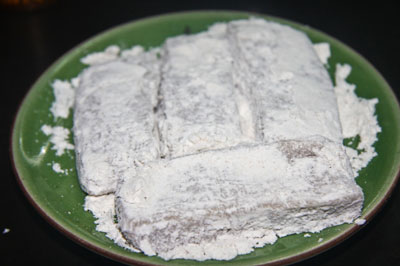 Cho bột nếp rang đổ từ từ v&agrave;o nồi, rồi d&ugrave;ng đũa khuấy đều