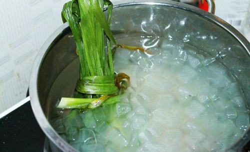 Cho 2.5 l&iacute;t nước c&ugrave;ng 250g đường ph&egrave;n v&agrave; l&aacute; dứa v&agrave;o nồi, mở lửa lớn
