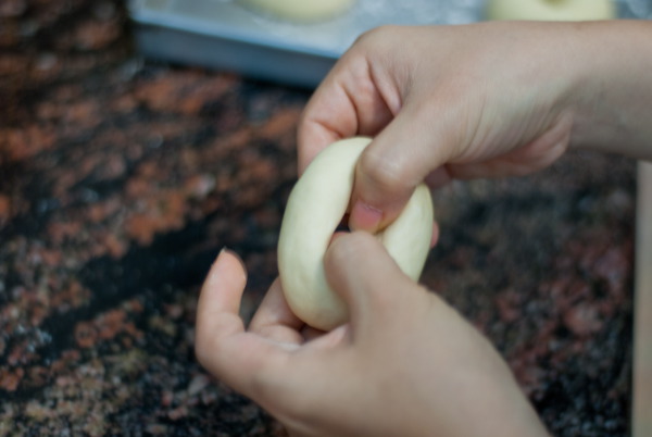 D&ugrave;ng tay tạo lỗ tr&ograve;n cho b&aacute;nh.