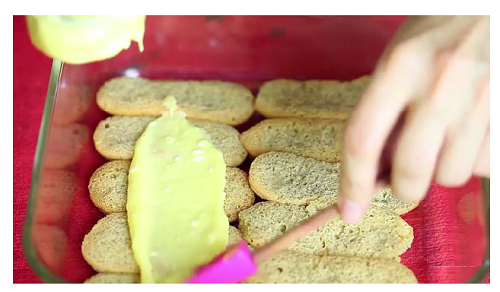 Th&ecirc;m một lớp phomat l&ecirc;n ph&iacute;a tr&ecirc;n lớp ladyfinger. D&ugrave;ng th&igrave;a d&agrave;n thật đều lớp phomat. Chỉ d&ugrave;ng một nửa hỗn hợp phomat.
