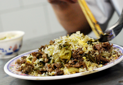 Lấy cơm rang dưa b&ograve; ra b&aacute;t hoặc đĩa, ăn n&oacute;ng.