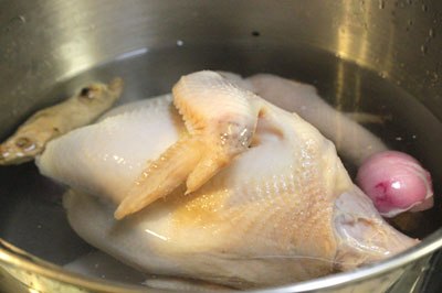 G&agrave; rửa sạch, nhổ lại l&ocirc;ng tơ cho thật sạch. Cho g&agrave; v&agrave;o nồi, th&ecirc;m gừng, h&agrave;nh kh&ocirc; nướng thơm v&agrave; một th&igrave;a canh muối, đun s&ocirc;i, thỉnh thoảng hớt bọt cho nước d&ugrave;ng được trong.