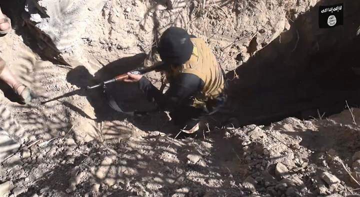 Một chiến binh của khủng bố ISIS nh&ocirc; l&ecirc;n từ một đường hầm 