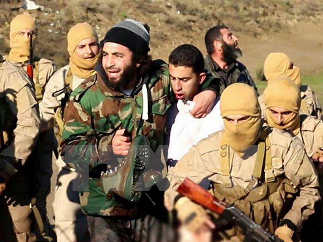 Maaz al-Kassasbeh (giữa) bị khủng bố IS bắt ng&agrave;y 24/12 tại Raqa, miền bắc Syria 