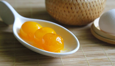 T&aacute;ch lấy l&ograve;ng đỏ trứng muối v&agrave; đặt l&ecirc;n nh&acirc;n ở giữa