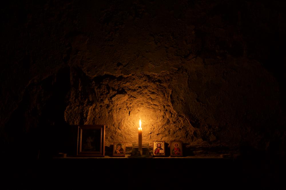 Ngọn nến lẻ loi thắp sáng bàn cầu nguyện do những người di tản lập ra tại nơi trú ẩn tự phát - vốn là tầng hầm bệnh viện ở quận Kievsky