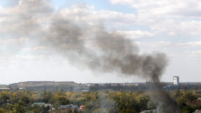 Cột kh&oacute;i bốc l&ecirc;n từ khu d&acirc;n cư gần s&acirc;n bay Donetsk sau c&aacute;c cuộc đụng độ giữa qu&acirc;n ch&iacute;nh phủ v&agrave; ly khai, hồi th&aacute;ng 10/2014