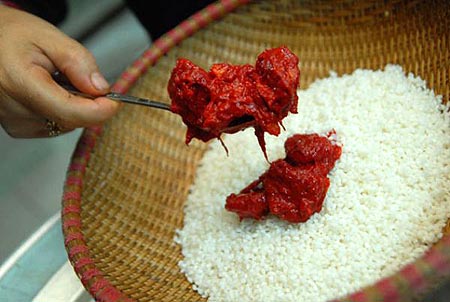 Trộn gạo nếp đ&atilde; ng&acirc;m mềm với thịt gấc cho thật đều