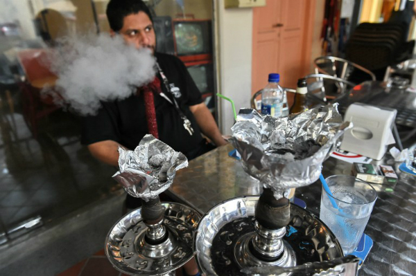 Người đ&agrave;n &ocirc;ng đang h&uacute;t shisha tại một qu&aacute;n c&agrave; ph&ecirc; ở Singapore
