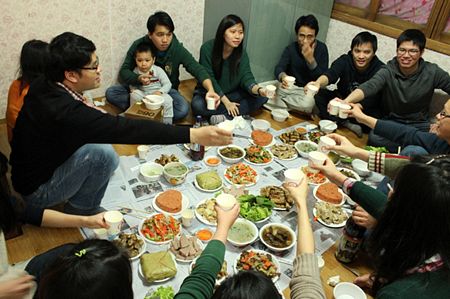 Trong bữa cơm c&uacute;ng Tất ni&ecirc;n, cả gia đ&igrave;nh ngồi qu&acirc;y quần b&ecirc;n nhau